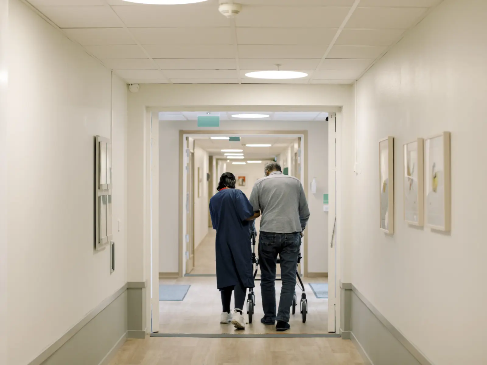Rear image of elderly man walking with medical guide.