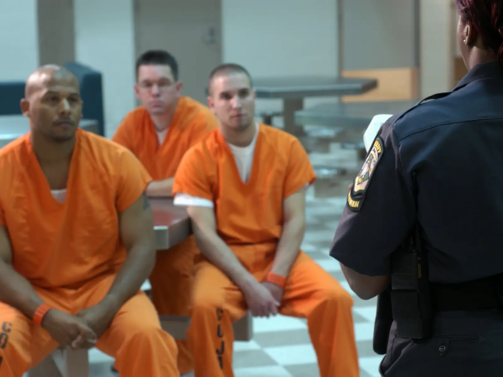 Image of inmates listening and talking with guard.