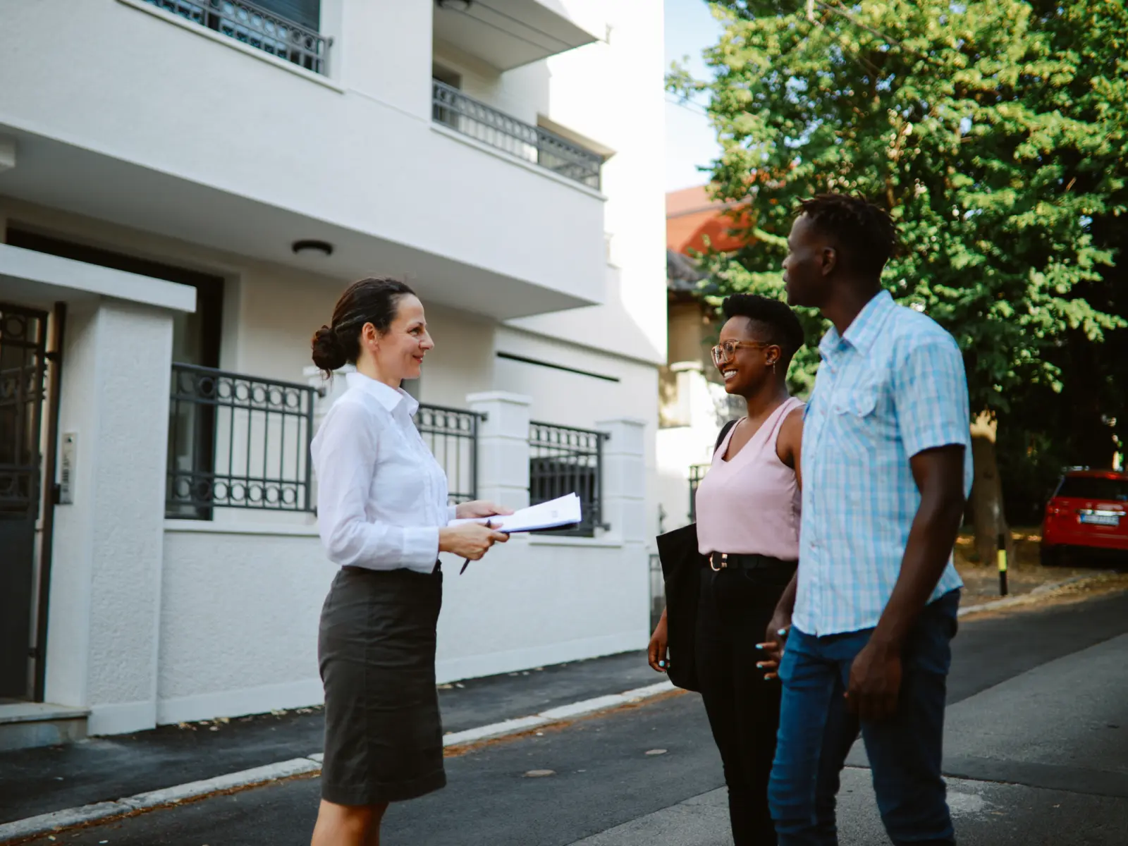 Image of female researcher speaking with couple on the street.