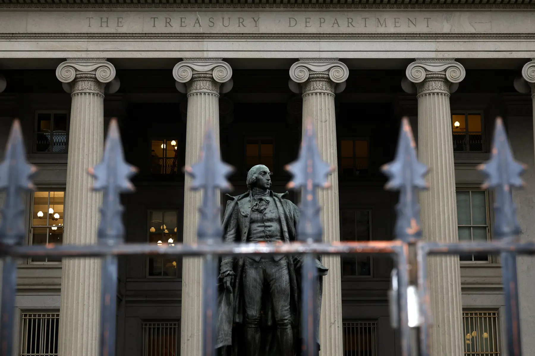 U.S. Treasury building with metal bars in foreground.