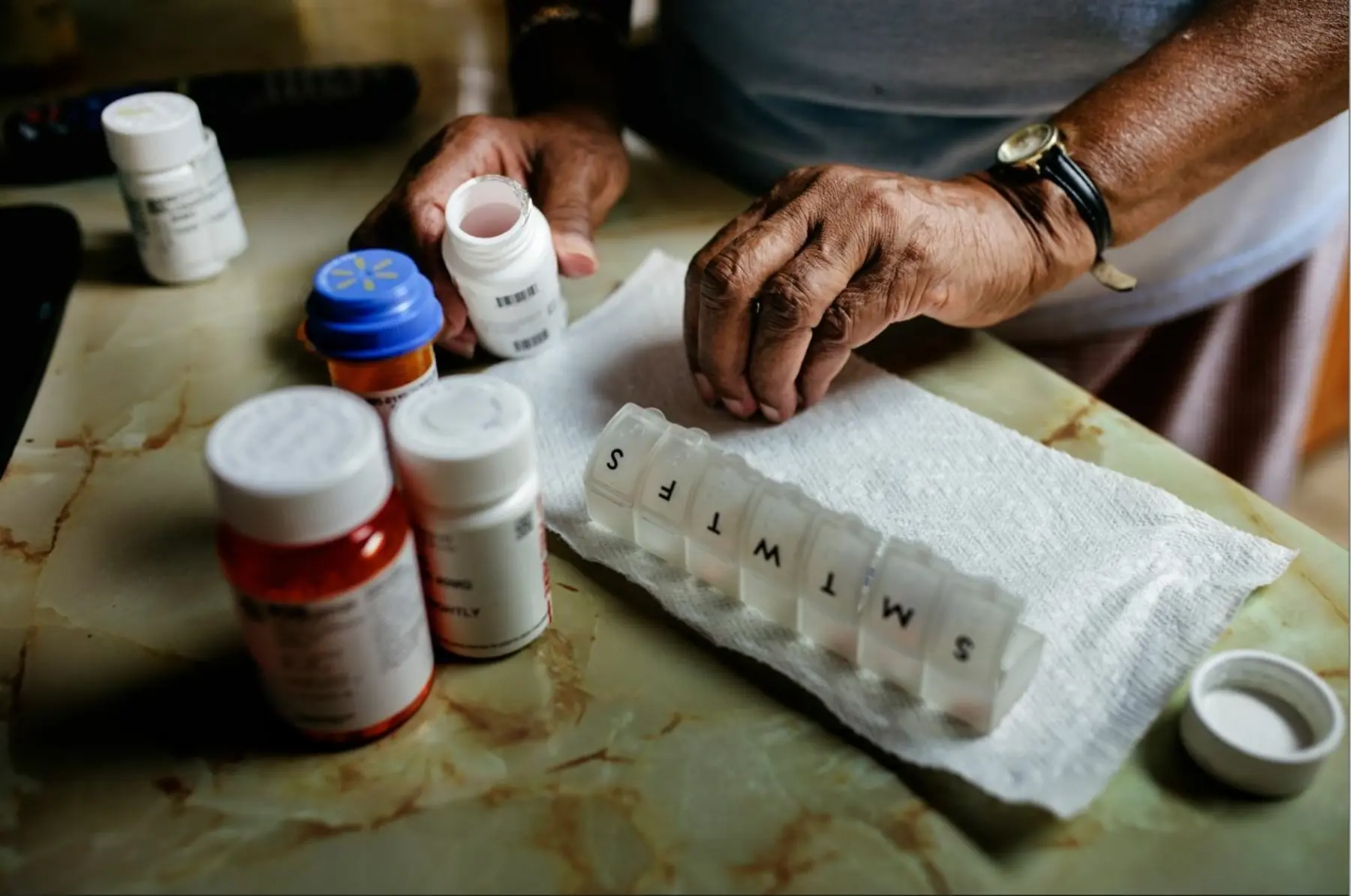 Elderly person organizing their weekly pills.