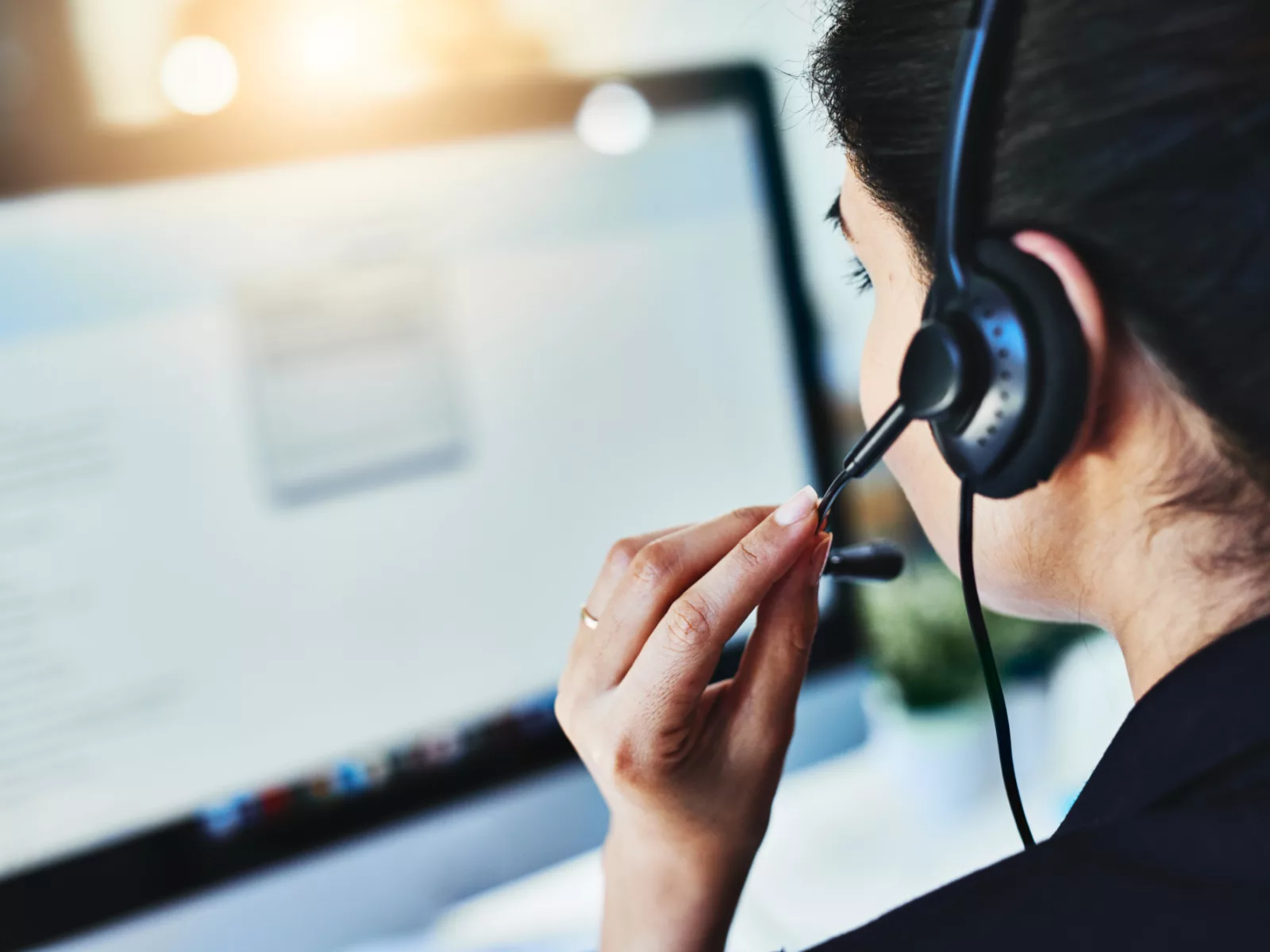 Female call center dispatcher looking at computer screen with the day's inquiries.