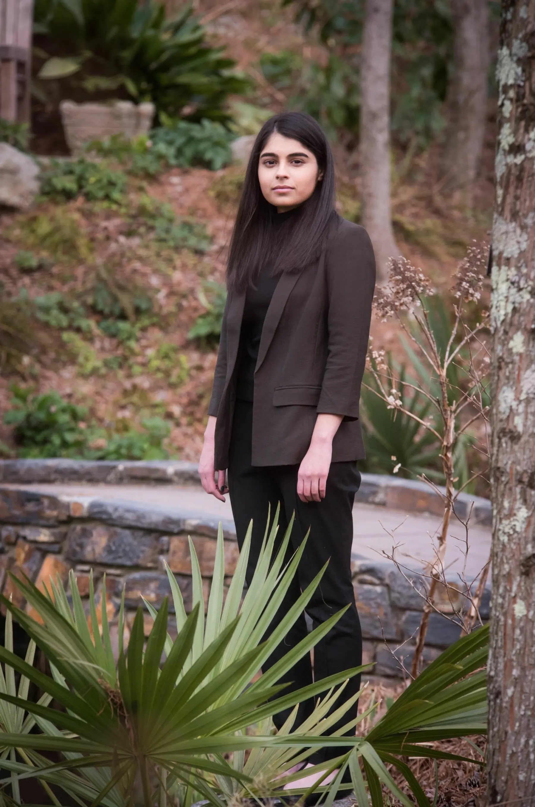 The subject of the story Sneha Dave stands in a wooded area looking directly at the camera.
