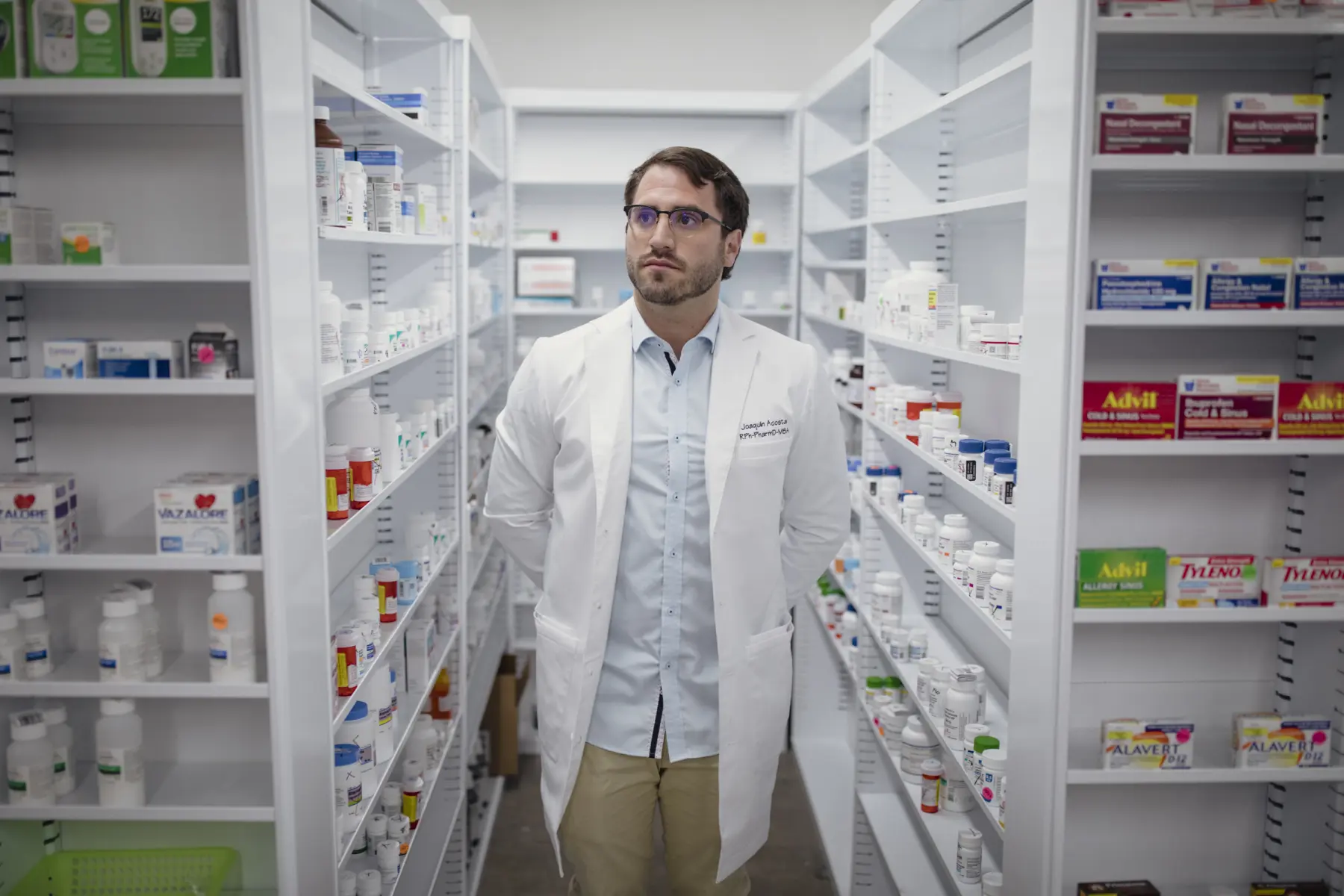 Pharmacist Joaquin Acosta stands among shelves of prescription drugs at his New Mexico pharmacy.