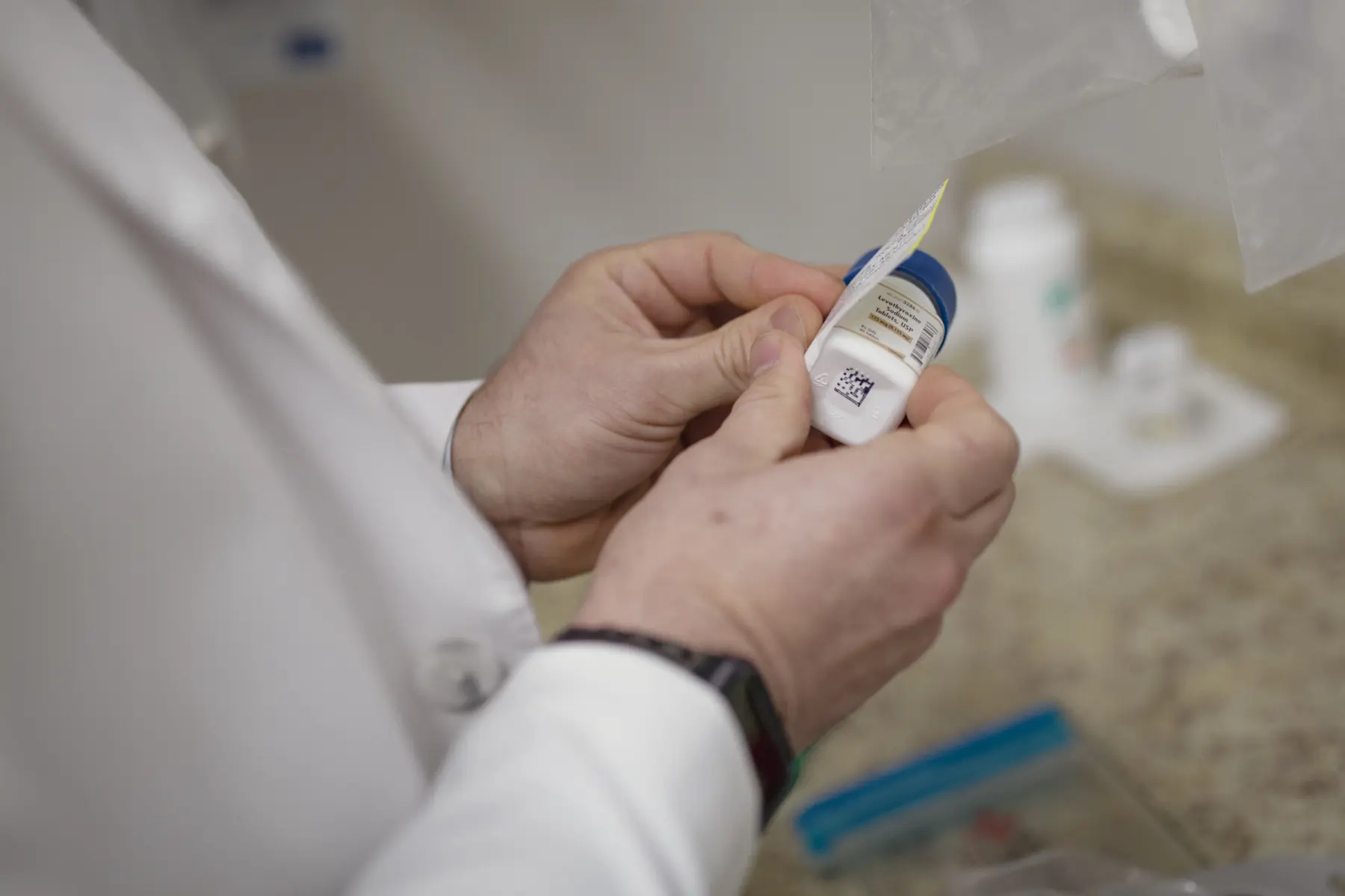 Pharmacist adds label to a bottle of pills.