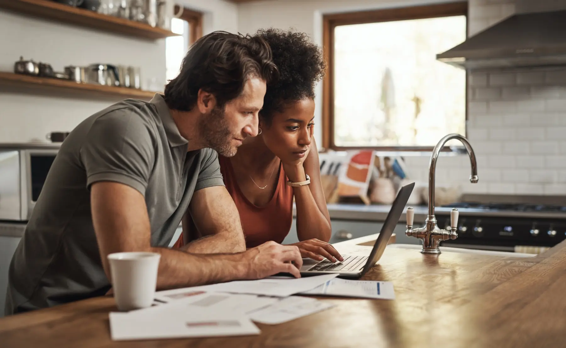 Man and women sitting at kitchen table reviewing bills