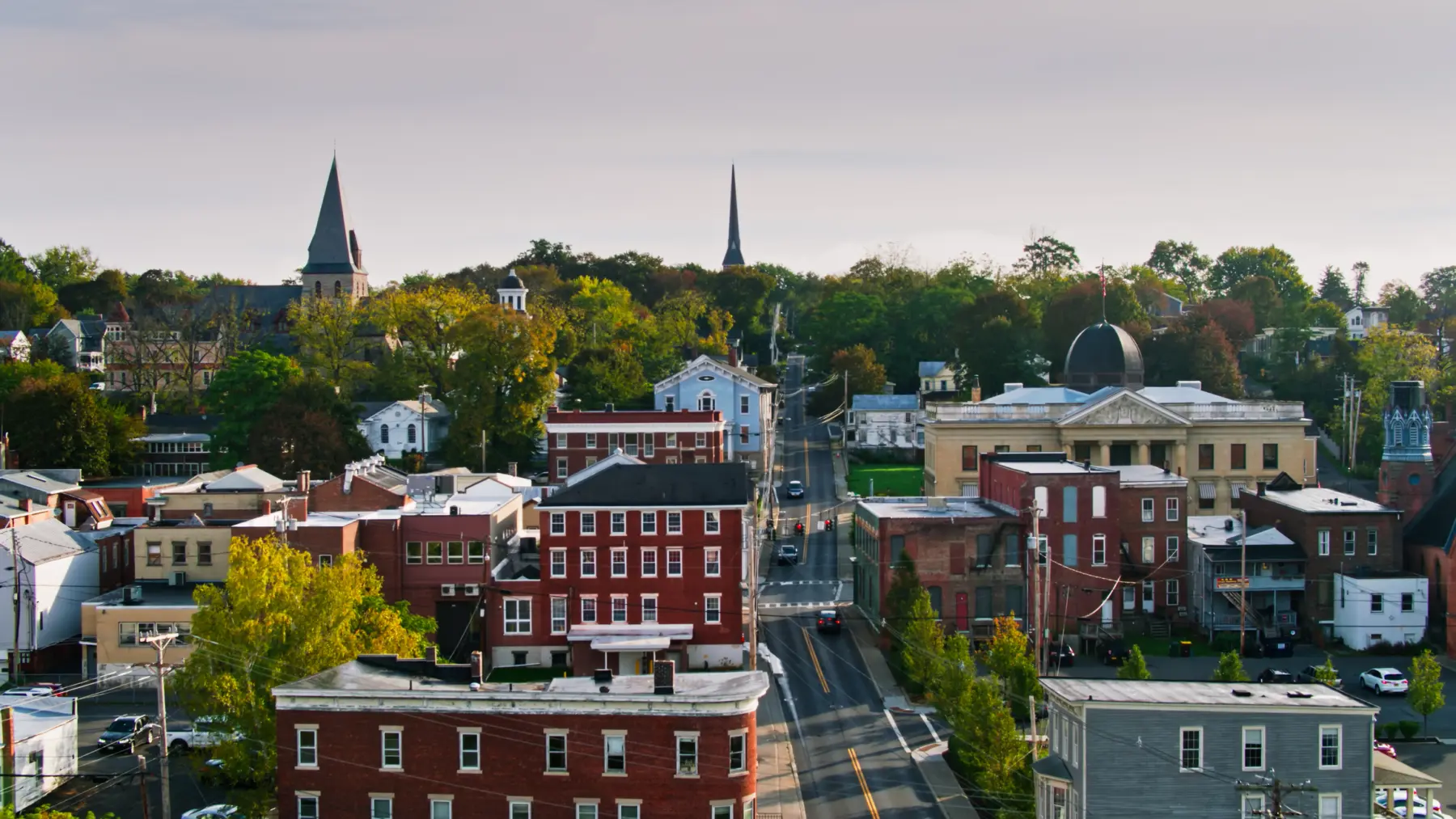 Aerial view of buildings and street in Catskill, New York with rolling fog over the mountains.